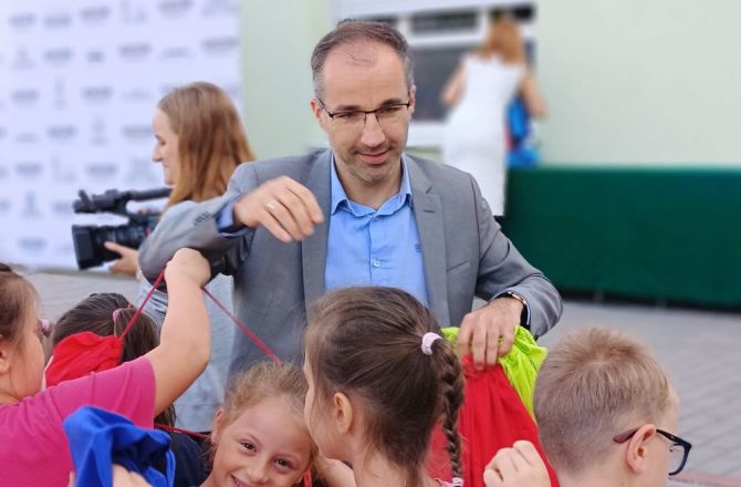 Prezes Łukasz Marcinkiewicz przekazuje pierwszakom eko-upominki